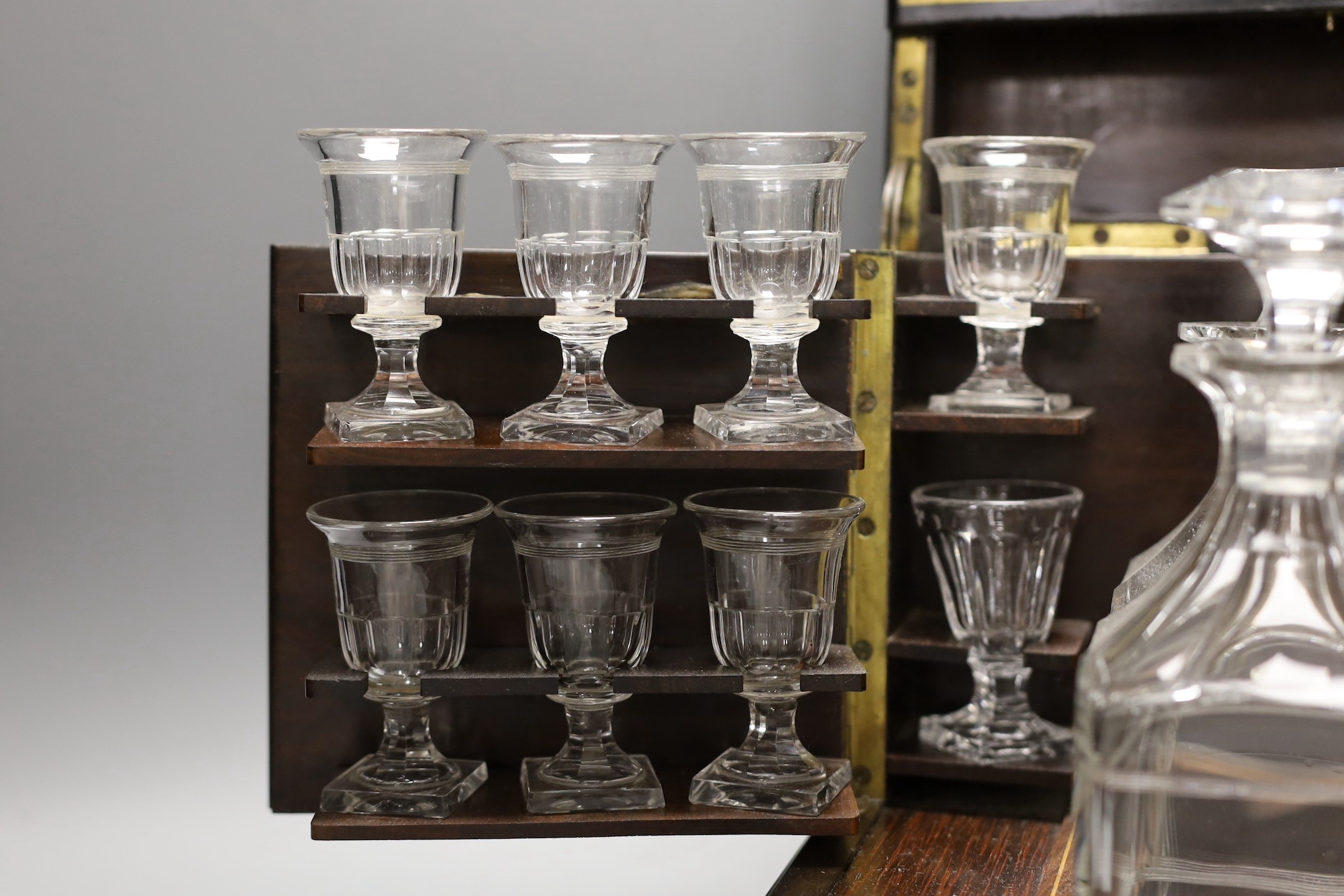 A 19th century mother of pearl and cut brass inlaid liqueur casket, 32cm, containing four original glass decanters and stoppers and 16 liqueur glasses